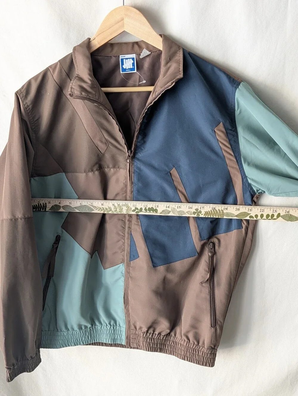 Undefeated Jacket in Taupe and Beige with Blue Logo Tag